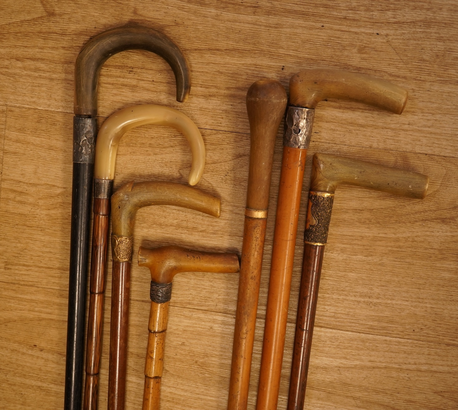 A collection of seven horn handles walking sticks some gold and white metal mounted